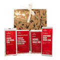Four red tea packages with white text on a gold gift box with floral patterns.