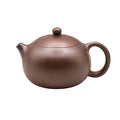 Xiao Xishi yixing clay woodfired teapot with a rounded body, short spout, and circular handle.