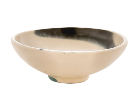 “Beige keramisch theeschaaltje met eenvoudige natuurlijke afwerking.”